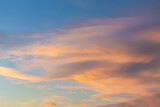 Dramatic cumulus clouds on sunny day at sunset painted with sun. Atmosphere multicolor background or wallpaper