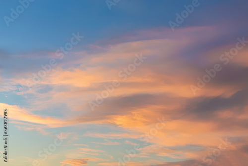 Dramatic cumulus clouds on sunny day at sunset painted with sun. Atmosphere multicolor background or wallpaper © Elena