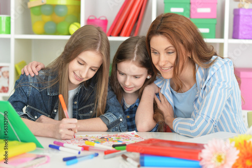 Teacher with girls drawing together at art class