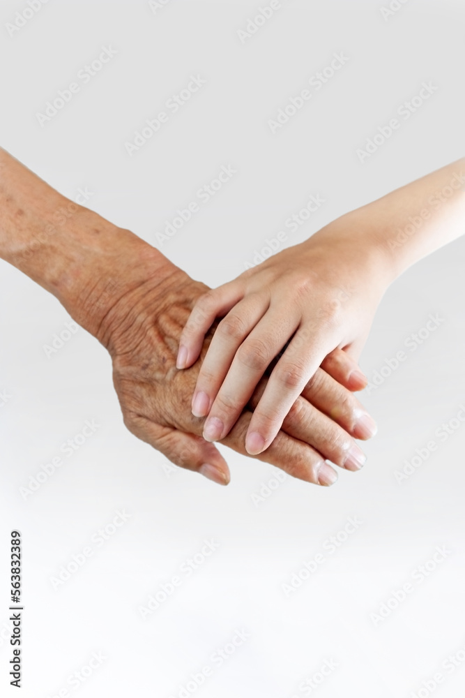 白背景の前で老人の手を握る子供の小さな手、敬老、介護、相続、福祉のイメージ