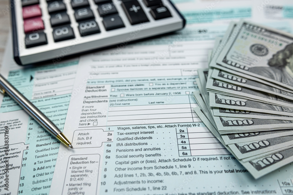 Obraz premium 2022 blank tax form with us dollar bills claculator pen on desk