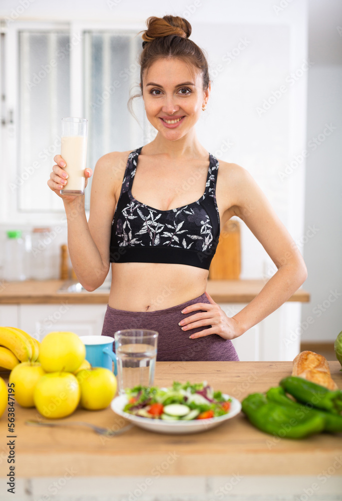 Slim girl drinking protein shake for weight loss in the kitchen Slim girl drinking protein shake for weight loss in the kitchen