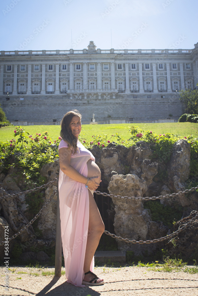Pregnant woman with pink dress in a park