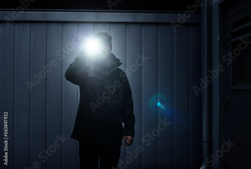 Watchman searching site with torchlight photo