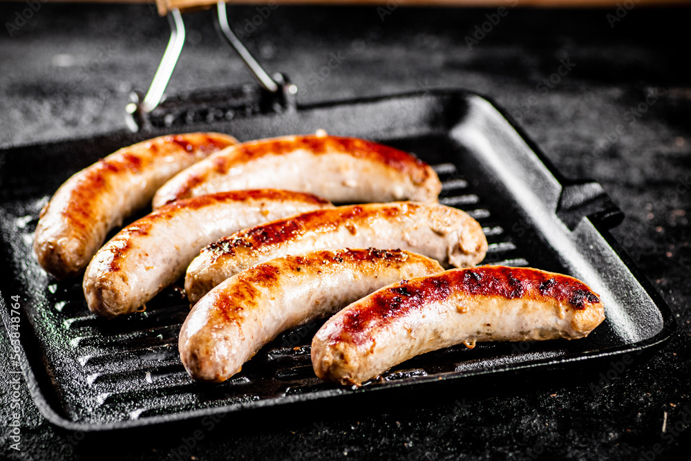 Grilled sausages in a frying pan. Grilled sausages in a frying pan.