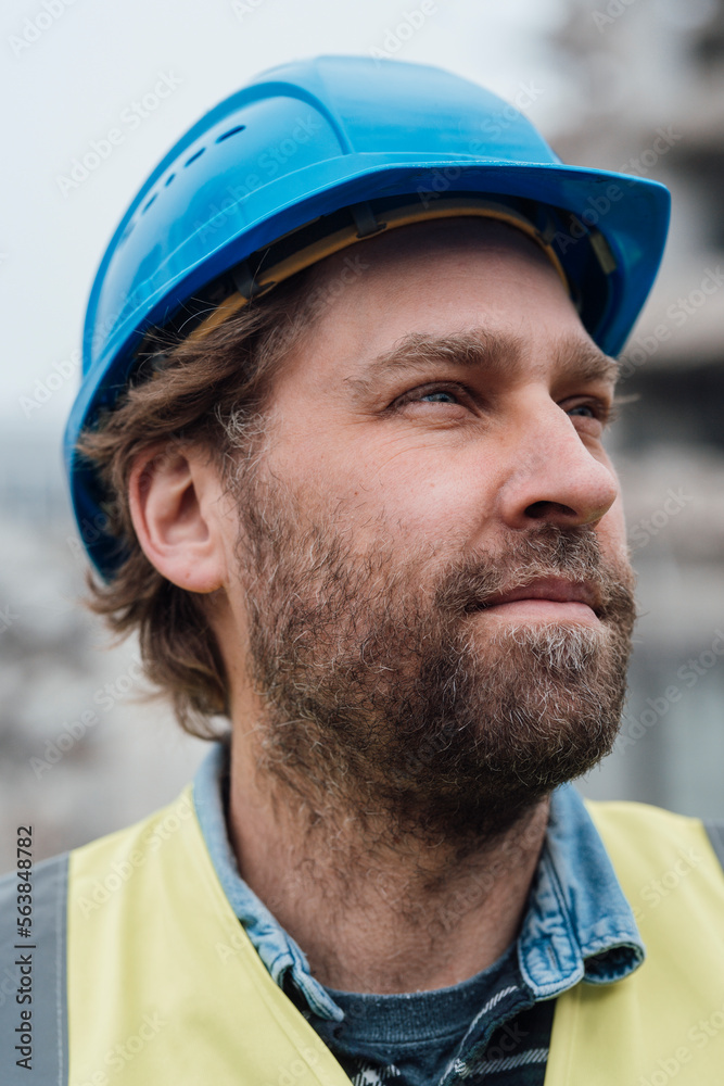 Thoughtful blue-collar worker wearing hardhat Thoughtful blue-collar worker wearing hardhat