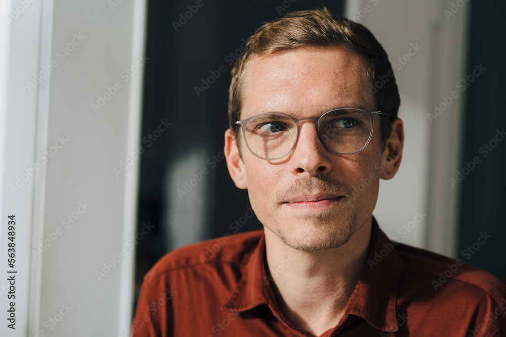 Contemplative businessman wearing eyeglasses at office Contemplative businessman wearing eyeglasses at office