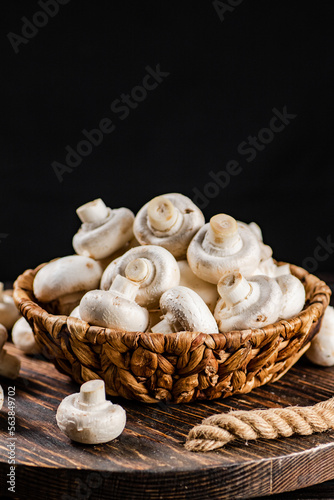 A full basket of mushrooms on a wooden tray. 