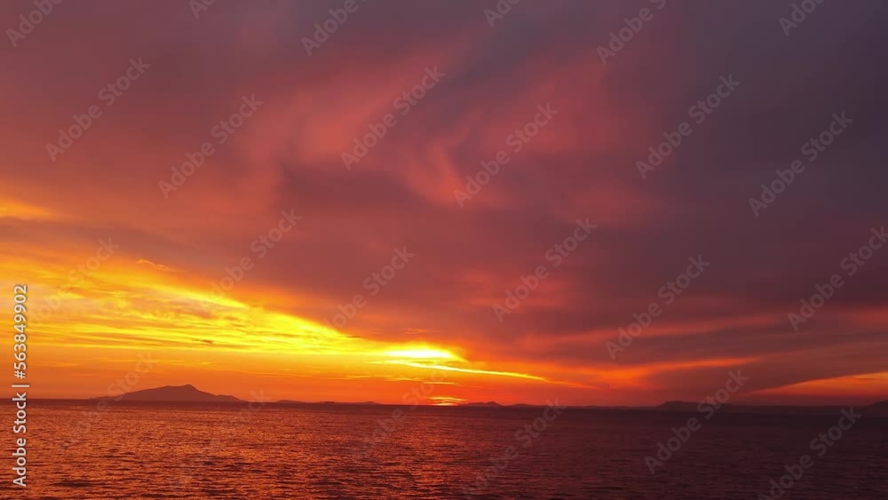 Majestic sunset or sunrise landscape. Beautiful cloudscape over the sea. Amazing light, pink and red sunset. Boats moving past. Red purple orange blue pink sunset sky cloud. Red sky, yellow sun. Majestic sunset or sunrise landscape. Beautiful cloudscape over the sea. Amazing light, pink and red sunset. Boats moving past. Red purple orange blue pink sunset sky cloud. Red sky, yellow sun.