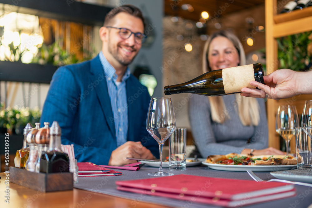Romantic couple enjoying lunch in the restaurant, eating pizza and drinking wine. Lifestyle, love, relationships, food concept