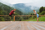 Athletic couple making namaste gesture during yoga practice on terrace in mountains