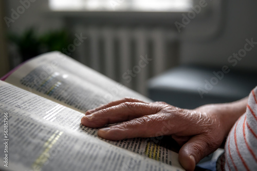 Photography An old woman reads the Bible, hands close up.