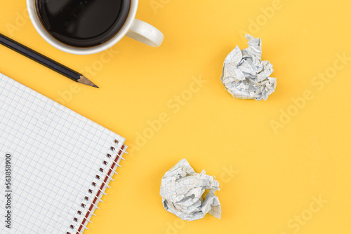 Empty notebook with cup of coffee and crumpled paper balls  flat lay.