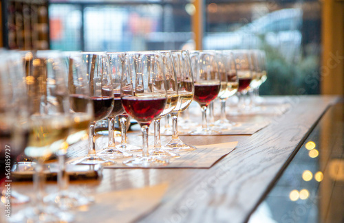 Wine glasses on wooden table filled with wine ready for wine tasting event 