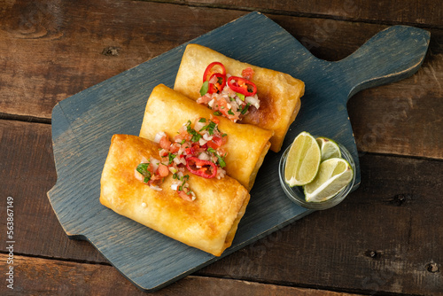 Chimichanga Mexican snack, top view, wooden table.