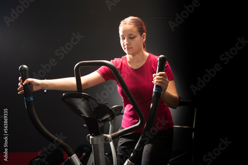 Young woman training nordic skiing in the gym