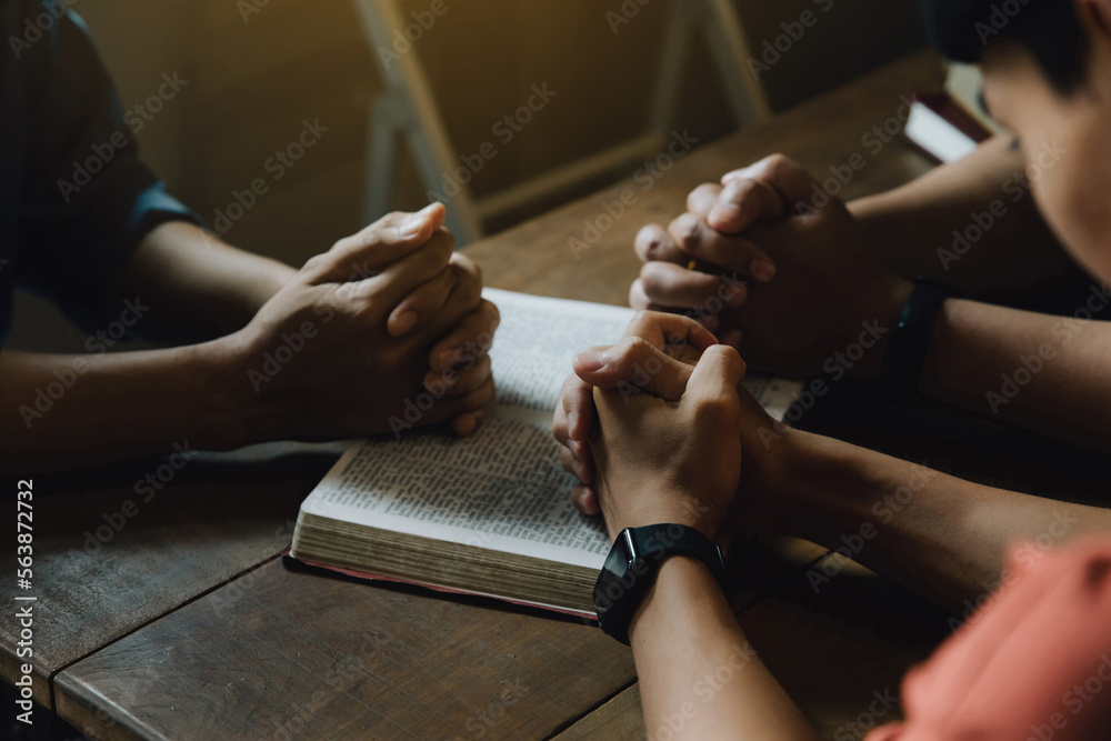 Christians and Bible study concept. Christians held each other's hands praying together and seeking the blessings of God,  They were reading the Bible and sharing the gospel. praying worship believe.