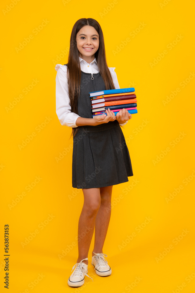 Back to school. Teenager schoolgirl with book ready to learn. School girl children on isolated yellow studio background.