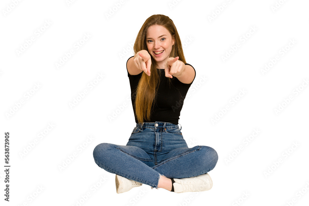 Young redhead woman sitting on the floor cut out isolated cheerful smiles pointing to front. Young redhead woman sitting on the floor cut out isolated cheerful smiles pointing to front.