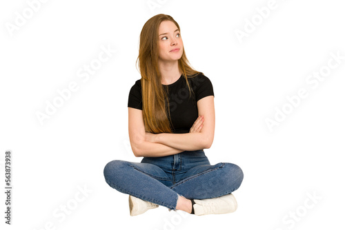 Young redhead woman sitting on the floor cut out isolated dreaming of achieving goals and purposes
