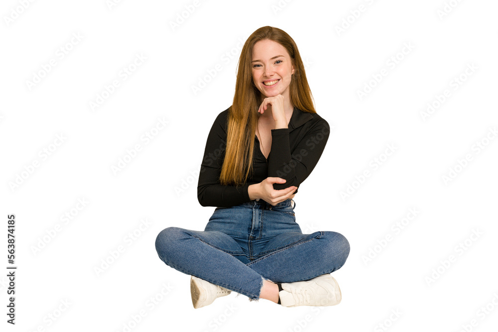 Young redhead woman sitting on the floor cut out isolated cheering carefree and excited. Victory concept.
