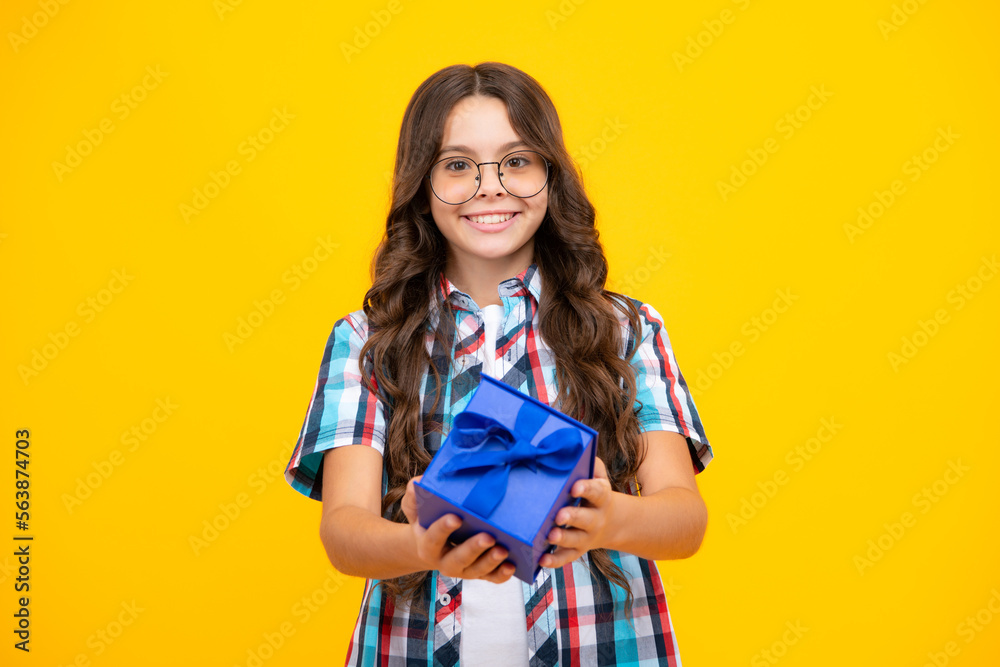 Emotional teenager child hold gift on birthday. Funny kid girl holding gift boxes celebrating happy New Year or Christmas.