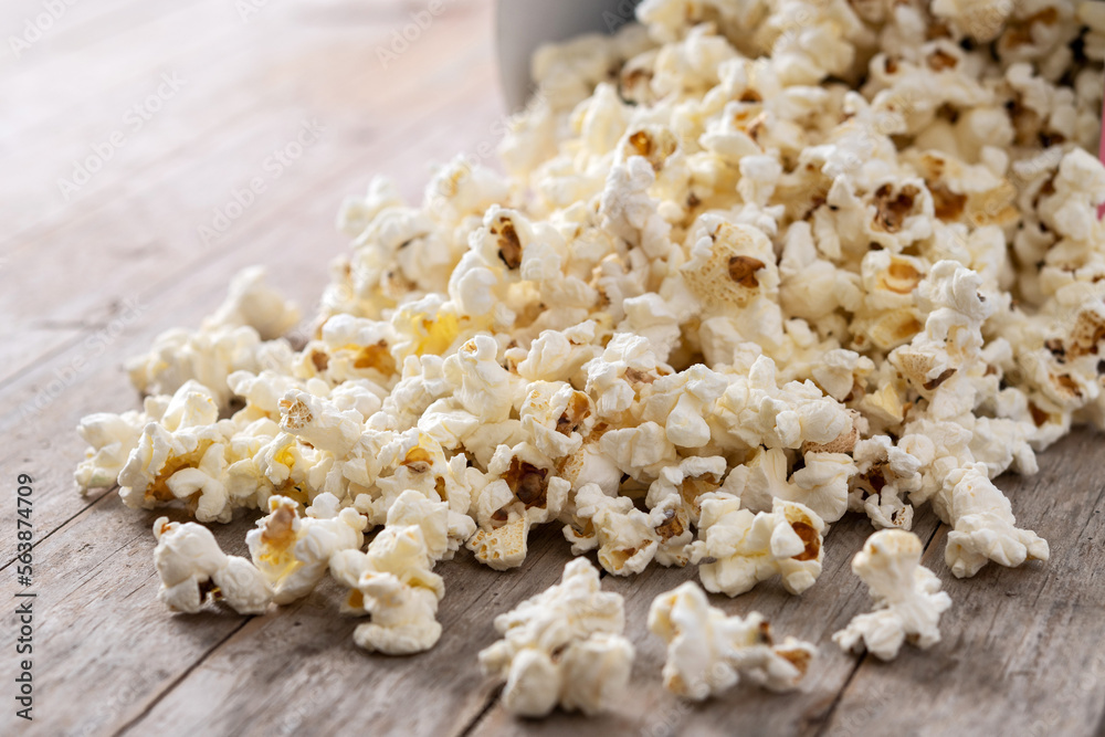 Salted popcorn scattered on wooden table. Copy space Salted popcorn scattered on wooden table. Copy space