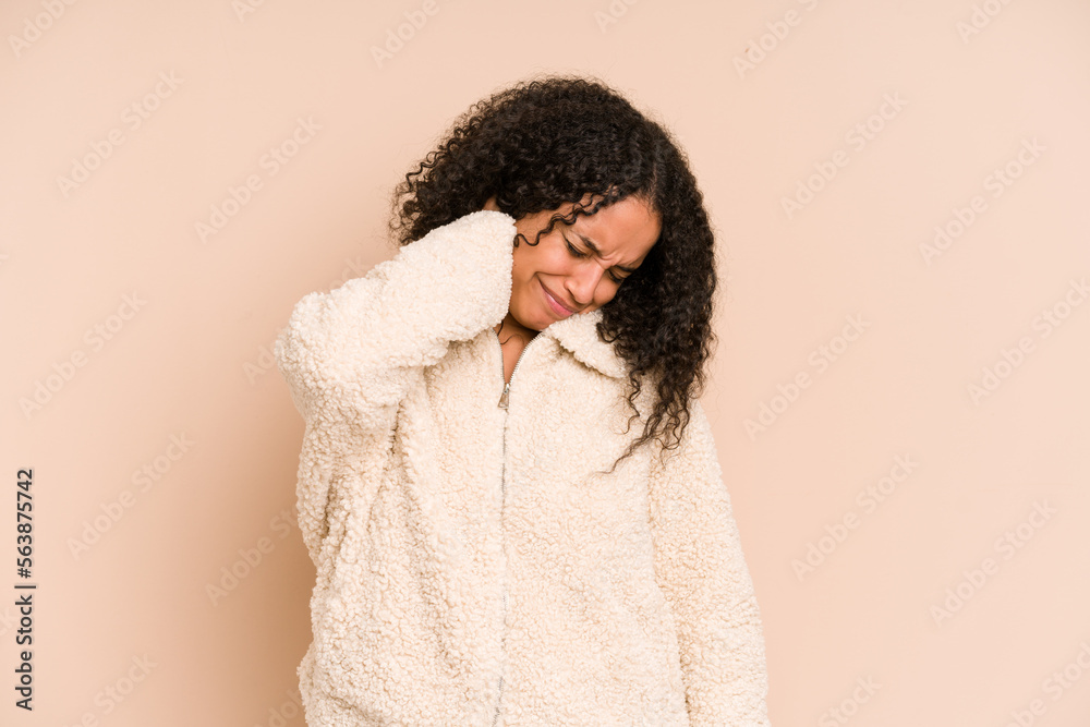 Young african american curly woman isolated having a neck pain due to stress, massaging and touching it with hand. Young african american curly woman isolated having a neck pain due to stress, massaging and touching it with hand.