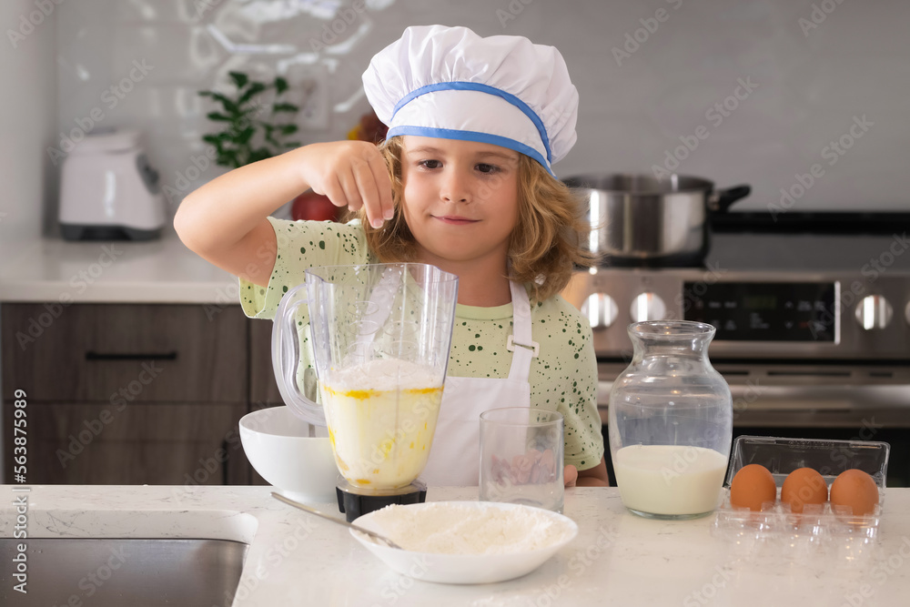 Funny kid chef cook cookery at kitchen. Chef kid boy making healthy food. Portrait of little child in chef hat. Funny kid chef cook cookery at kitchen. Chef kid boy making healthy food. Portrait of little child in chef hat.