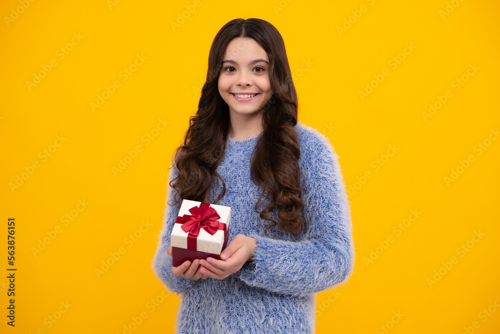 Happy teenage girl. Teenager child holding gift box on isolated yellow background. Gift for kids birthday. Christmas or New Year present box. Smiling kids emotions. Happy teenage girl. Teenager child holding gift box on isolated yellow background. Gift for kids birthday. Christmas or New Year present box. Smiling kids emotions.