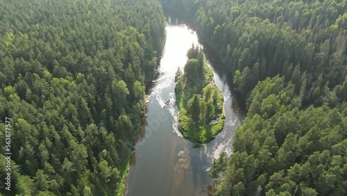 Aerial drone shot of forests and river valley with sunset in Sigulda, Gauja National Park, Latvia. There are many small islands located among the river. Flying over lakeland and forest. Pristine 
