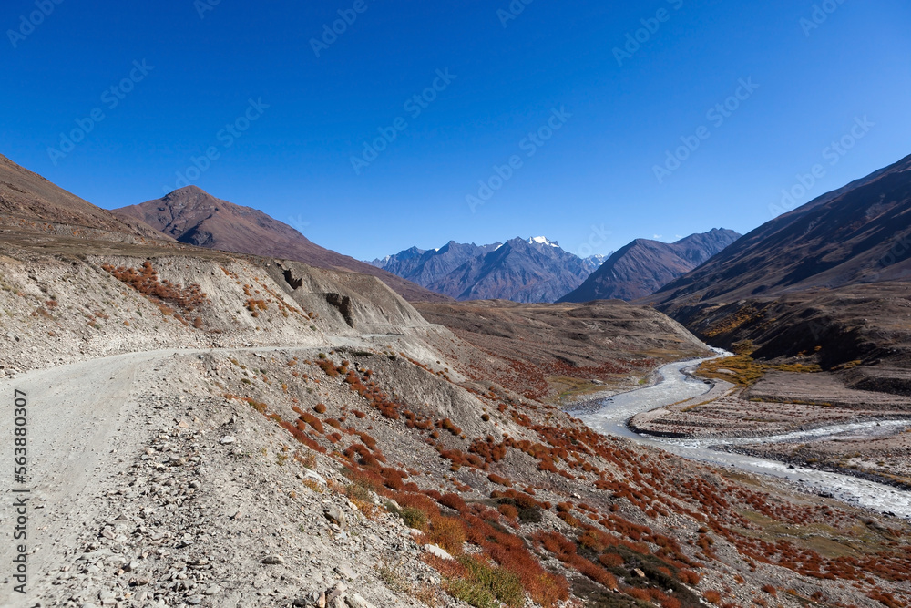 Road in Zanskar valley, Ladakh near Padum. Moto travel in India. Beautiful remote road and snowy mountain peaks.
