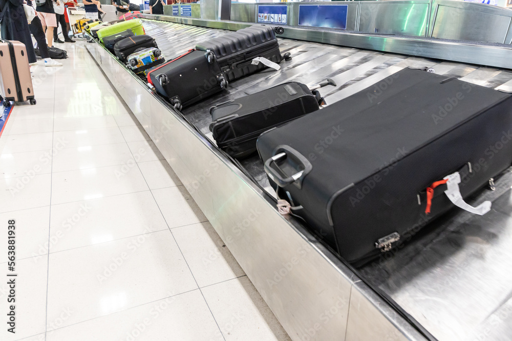 Baggage luggage at airport arrival carousel with passengers awiating to claim theirs Baggage luggage at airport arrival carousel with passengers awiating to claim theirs