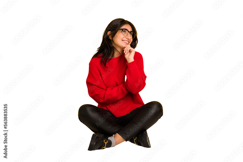 Young indian woman sitting on the floor cut out isolated relaxed thinking about something looking at a copy space. Young indian woman sitting on the floor cut out isolated relaxed thinking about something looking at a copy space.