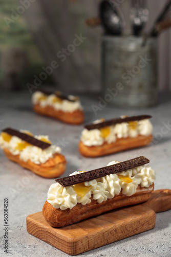 Classic éclairs adorned with dark chocolate bars, the whipped cream filling creating a tempting contrast with the rich topping.