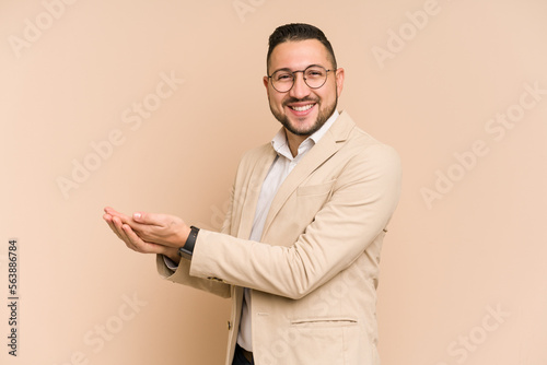 Adult latin business man cut out isolated holding a copy space on a palm. © Asier