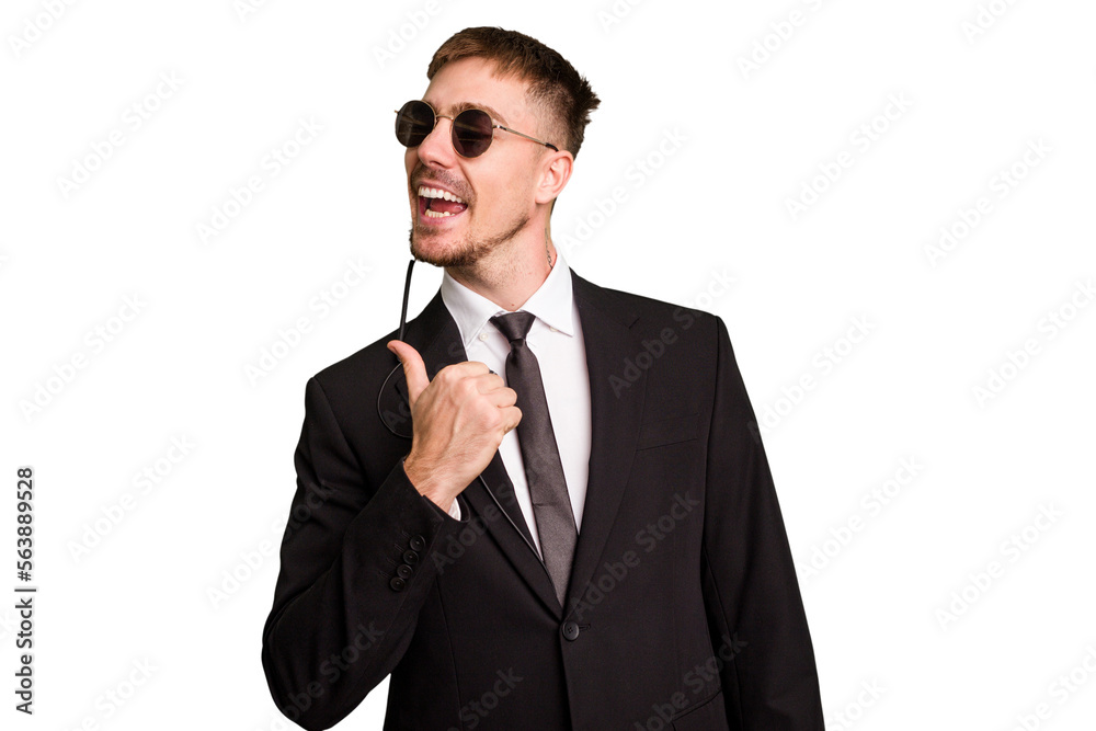 Security bodyguard man wearing a suit isolated cut out points with thumb finger away, laughing and carefree. Security bodyguard man wearing a suit isolated cut out points with thumb finger away, laughing and carefree.