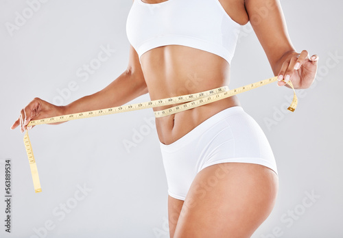 Weight loss, measure tape and wellness of a black woman beauty model with  stomach measurement. Portrait of a woman checking health, diet and healthy  fitness progress feeling happy with a smile