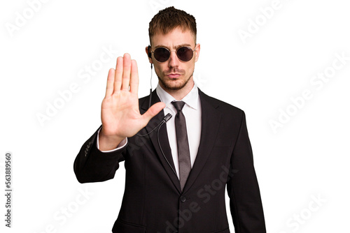 Security bodyguard man wearing a suit isolated cut out standing with outstretched hand showing stop sign, preventing you.