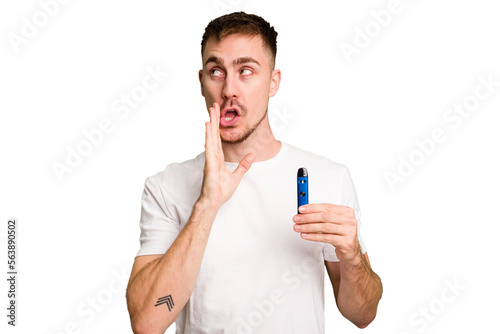 Young caucasian man holding a vaporizer cut out isolated is saying a secret hot braking news and looking aside