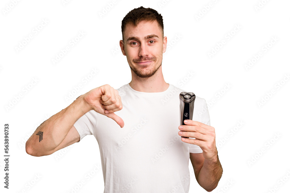 Young man holding a shaving machine cut out isolated showing a dislike gesture, thumbs down. Disagreement concept. Young man holding a shaving machine cut out isolated showing a dislike gesture, thumbs down. Disagreement concept.