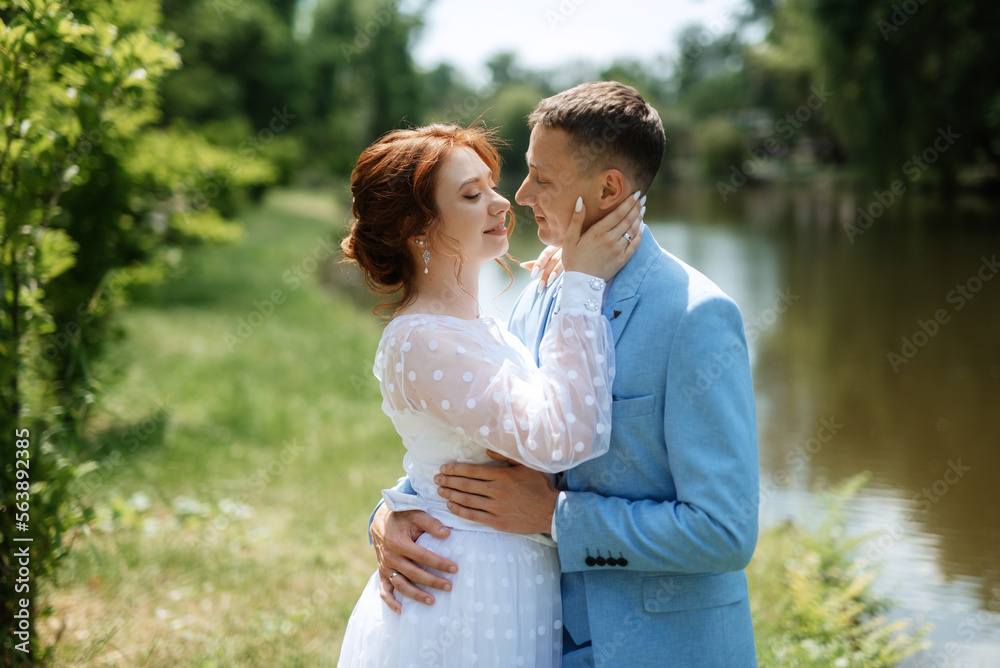 bride in a light wedding dress to the groom in a blue suit bride in a light wedding dress to the groom in a blue suit