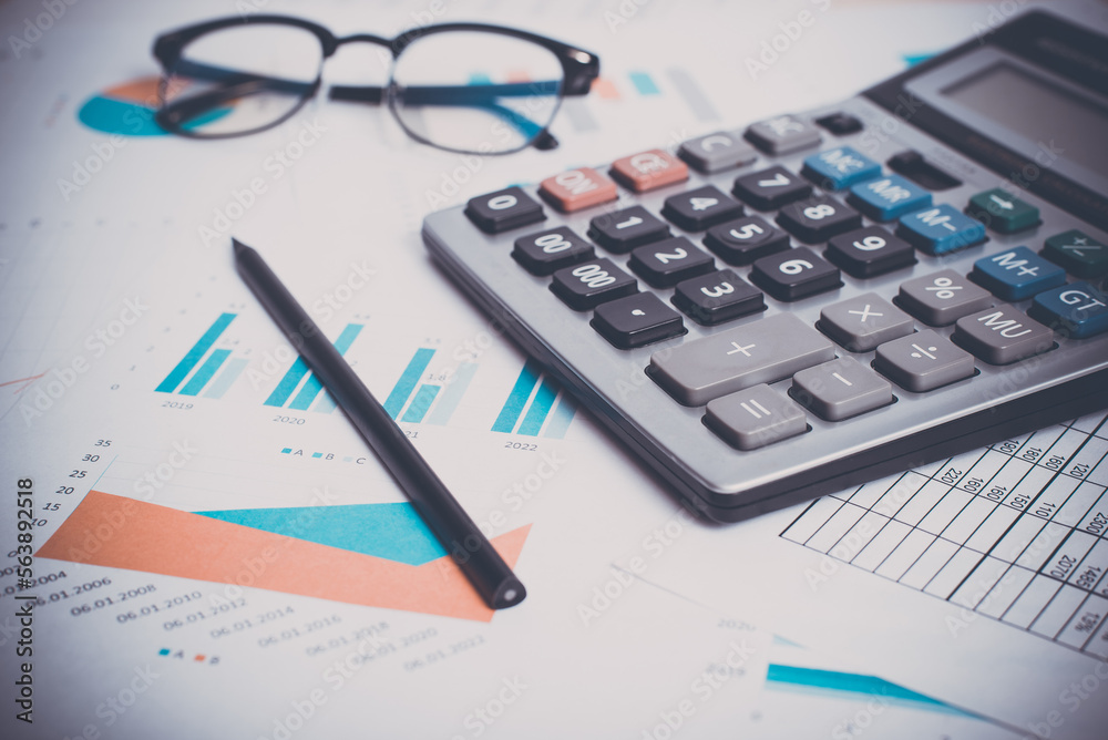 Accounting and financial concept. Close-up calculator, business documents, pencil glasses at workplace. Low angle view, selective focus Accounting and financial concept. Close-up calculator, business documents, pencil glasses at workplace. Low angle view, selective focus