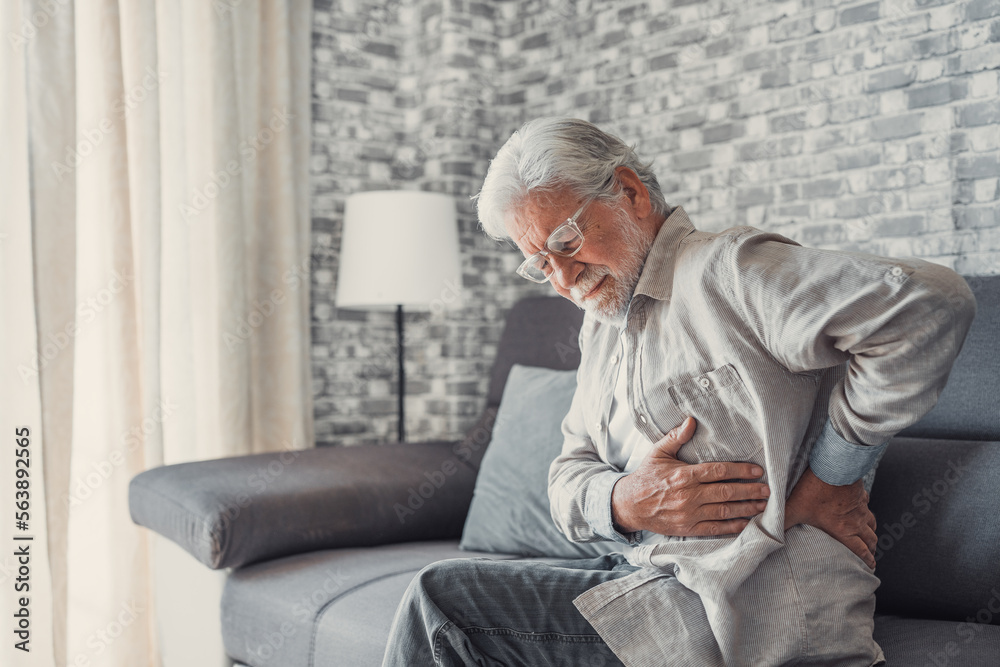 Upset senior elder man feel sudden back pain muscles ache tension injury sitting at home, sad old grandfather touching spine having lower lumbago backache osteoarthritis arthritis, backache concept. Upset senior elder man feel sudden back pain muscles ache tension injury sitting at home, sad old grandfather touching spine having lower lumbago backache osteoarthritis arthritis, backache concept.
