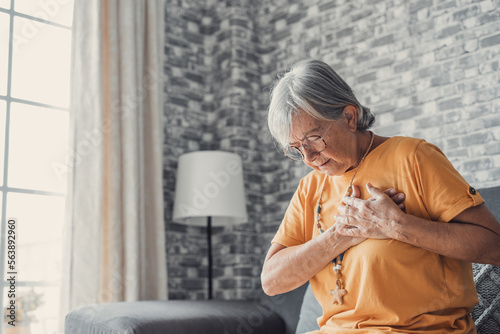Upset stressed mature middle aged woman feeling pain ache touching chest having heart attack, sad worried senior older lady suffers from heartache at home, infarction or female heart disease concept.