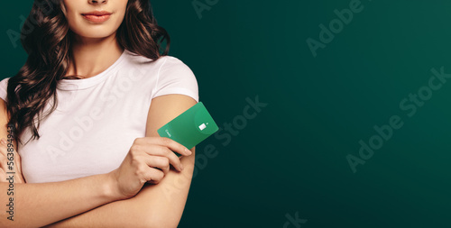 Banking with credit: Female credit card holder stands in a studio with her arms crossed photo