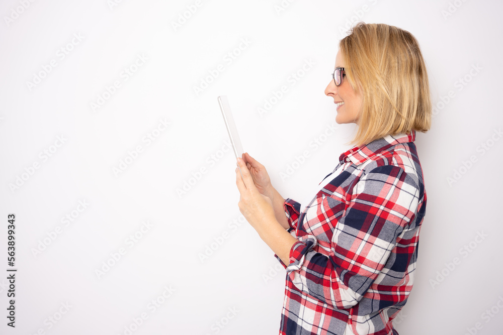 Side view Photo of optimistic blonde nice lady hold tablet wear eye wear plaid shirt isolated on white background