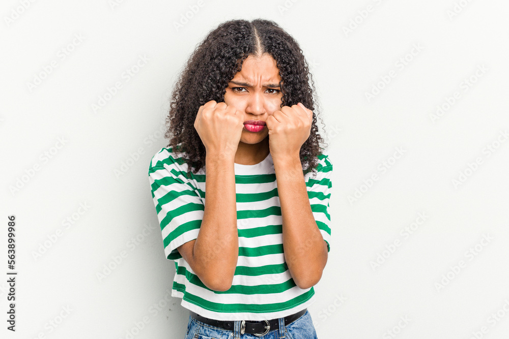 Young african american woman isolated on white background throwing a punch, anger, fighting due to an argument, boxing. Young african american woman isolated on white background throwing a punch, anger, fighting due to an argument, boxing.