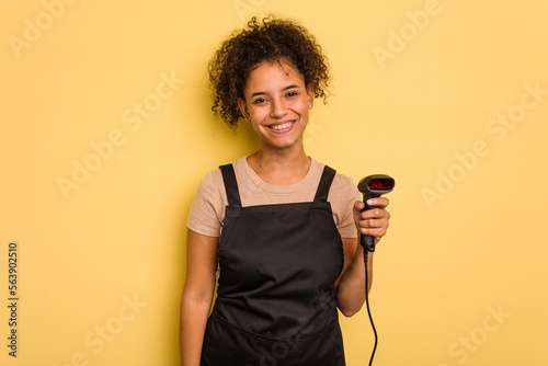 Young brazilian work woman holding a hand sticker price label machine isolatedYoung brazilian woman holdihappy, smiling and cheerful. photo