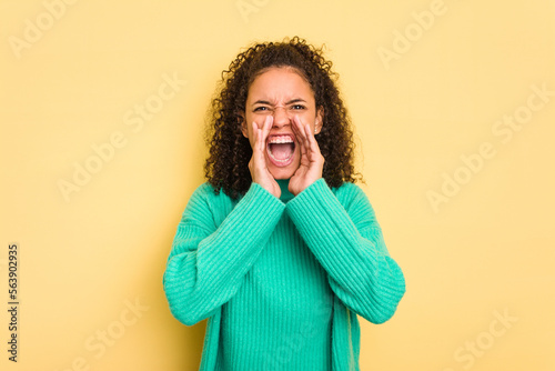 Фототапет Young Brazilian curly hair cute woman isolated on yellow background shouting excited to front